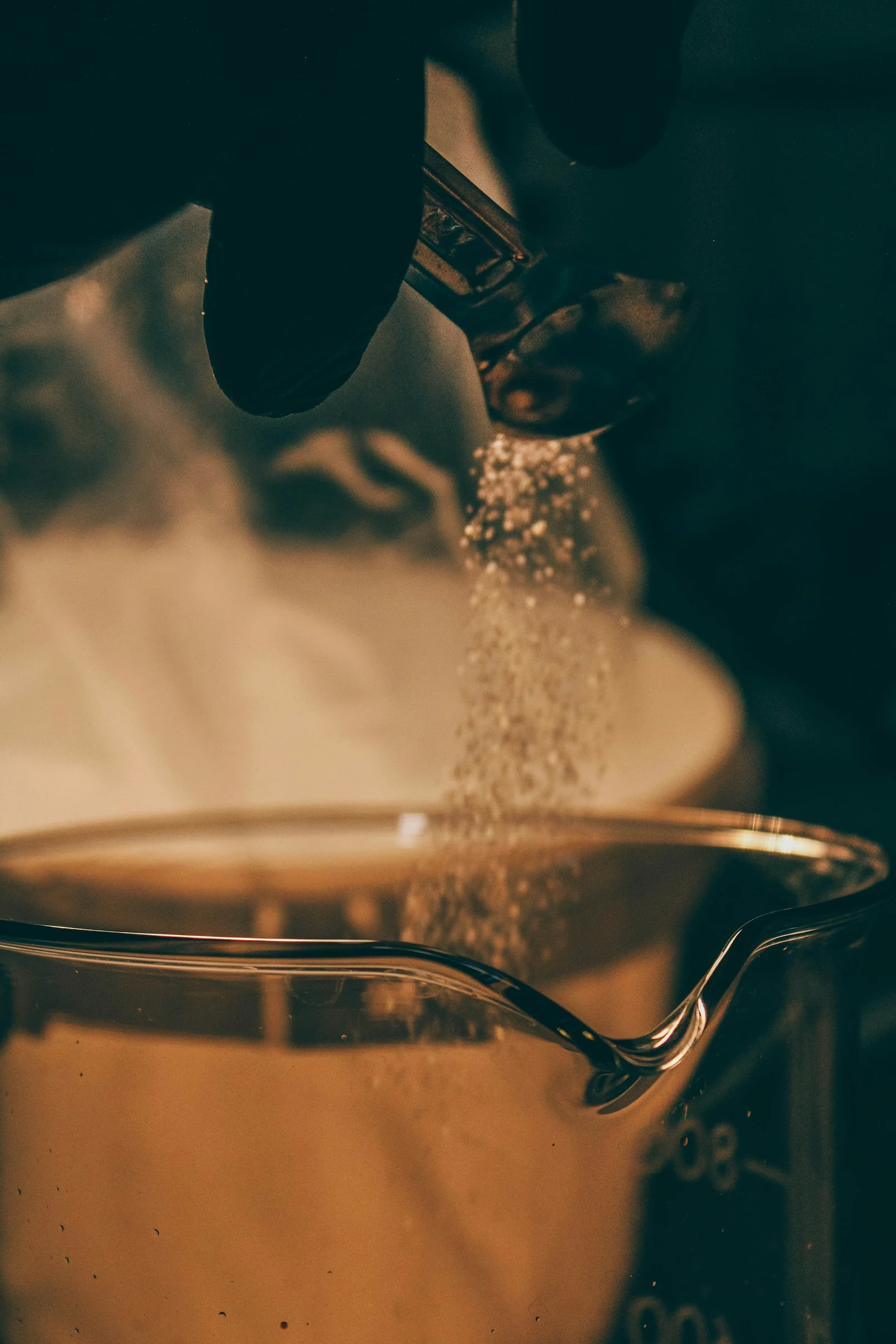 Powdered fragrance ingredient being measured into laboratory glassware